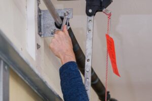 Close-up of a technician using a wrench to adjust a garage door spring.